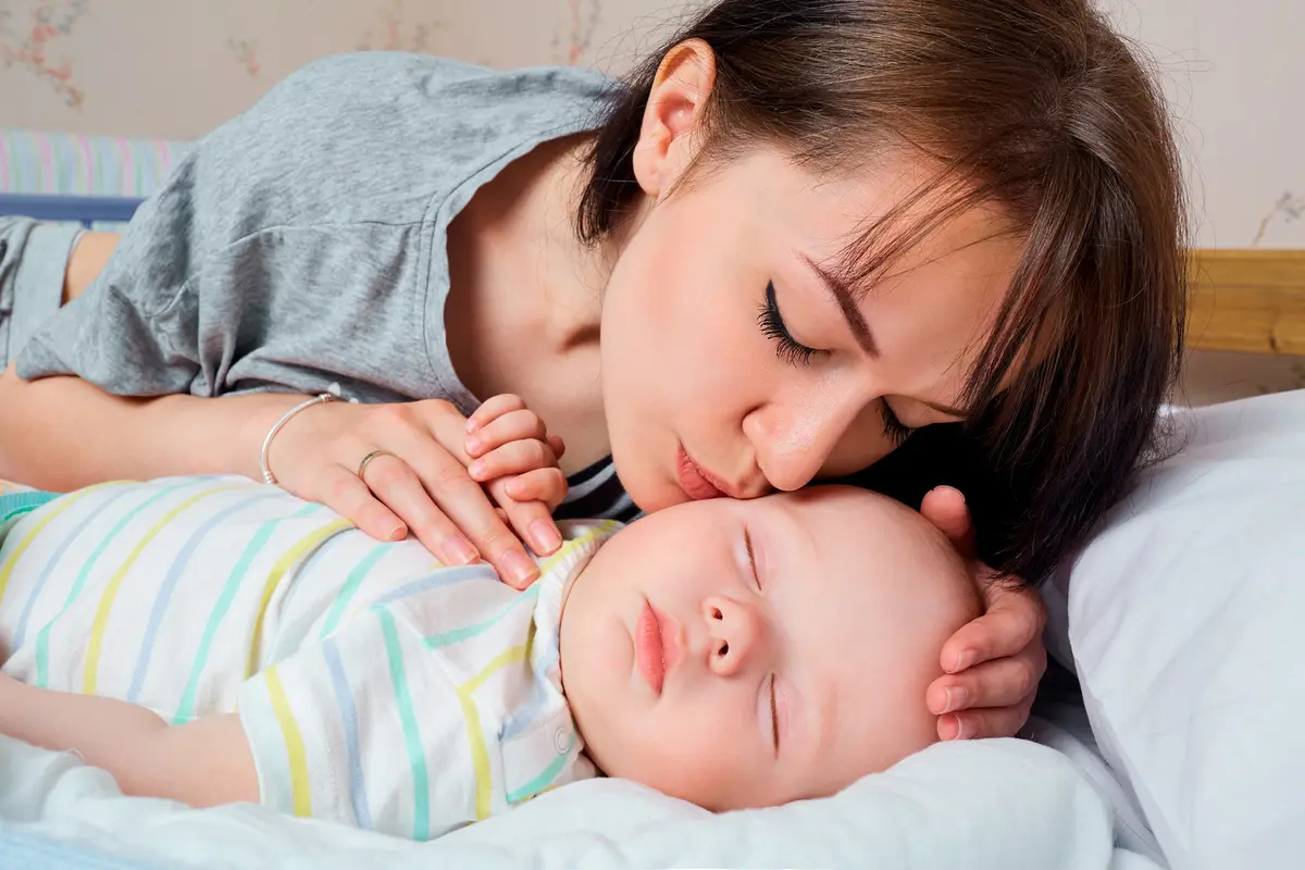 Kacey kissing a sleeping baby