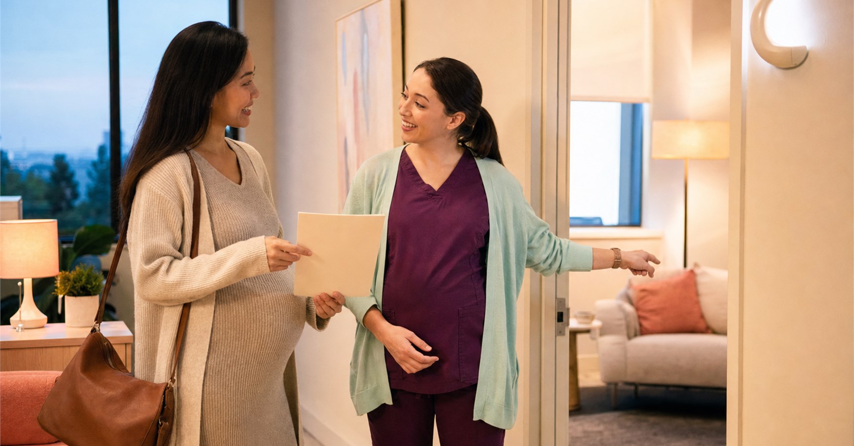 Pregnant woman holding an appointment folder smiles as a clinician welcomes her into a consultation room.