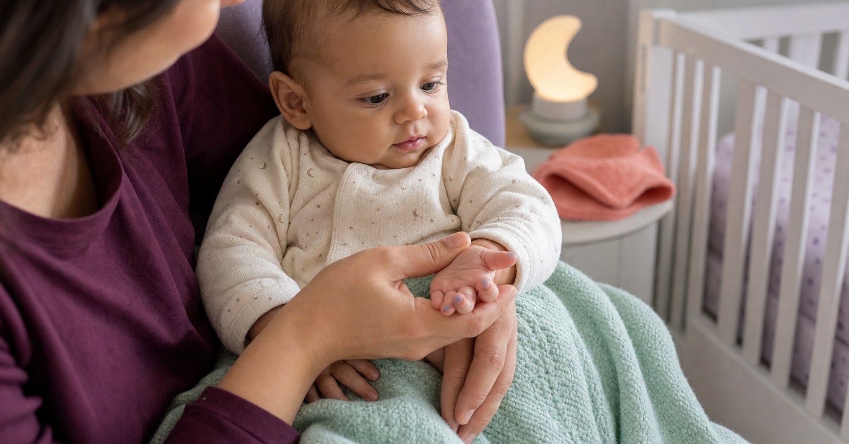 Caregiver gently examining a calm baby's subtly blue-tinted fingernails beside an empty crib