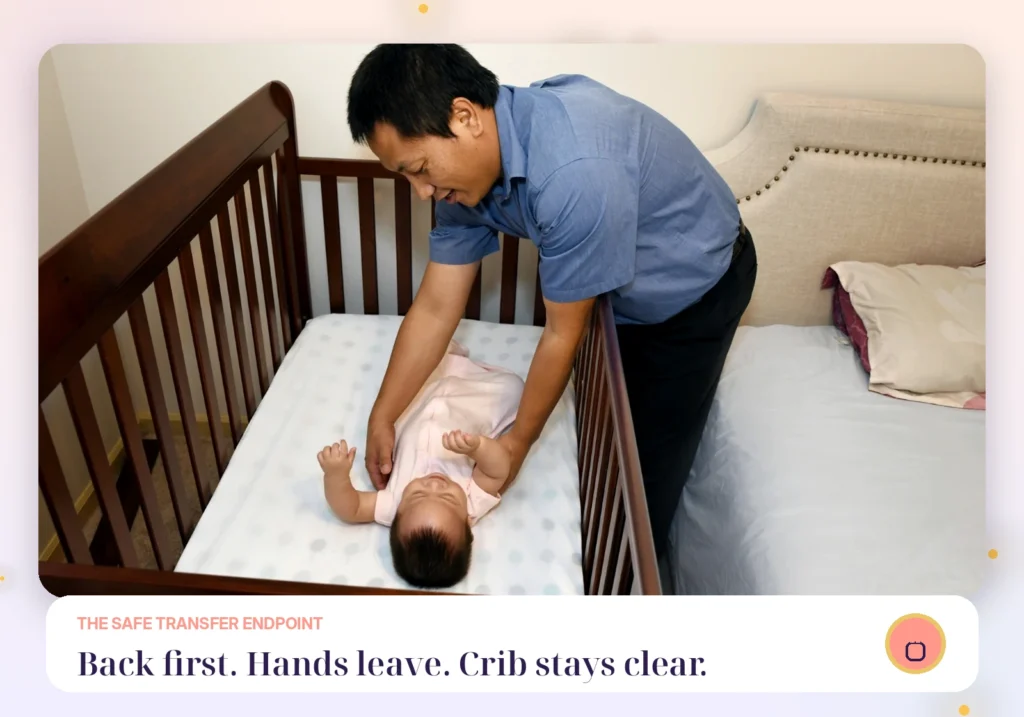 Father leaning over a wooden crib while placing a baby on their back on a fitted sheet with the crib otherwise empty