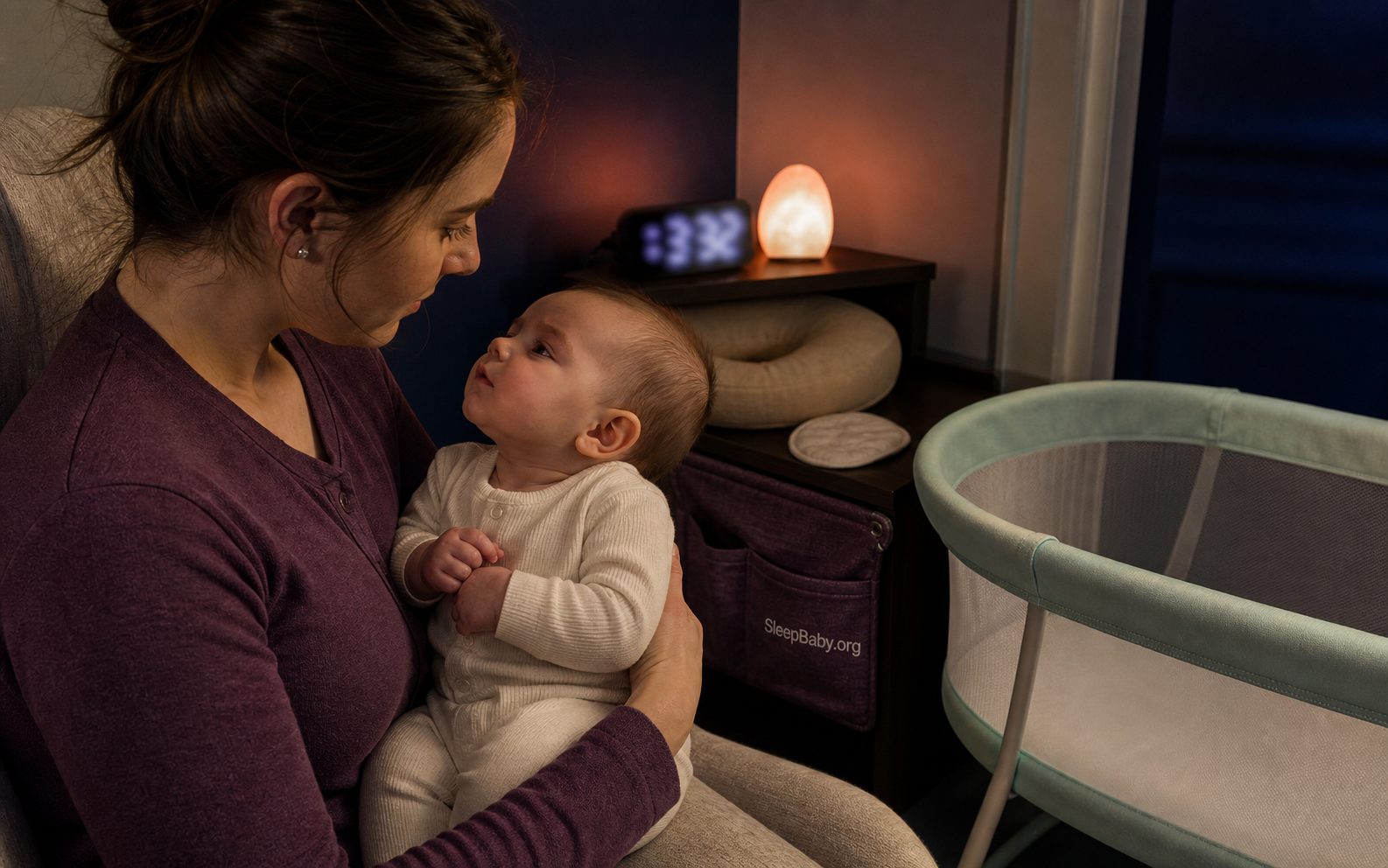 Parent studies an awake baby's feeding cues after a night feed beside a blurred clock and an empty bassinet